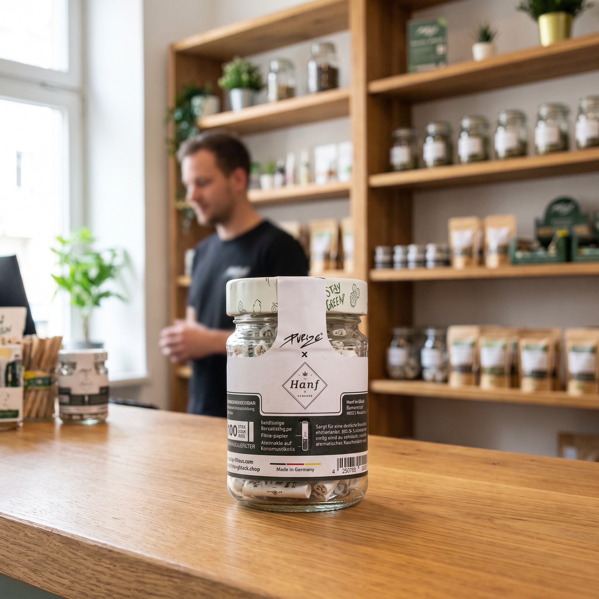 Hanf im Glück x Purize XTRA Slim Glas – Purize Filterglas steht auf der Holztheke eines Hanf-Fachgeschäfts